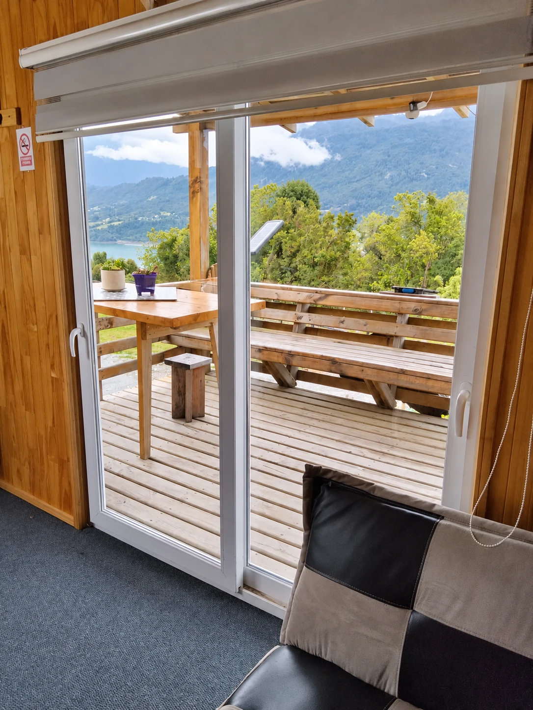 Terraza con mesa de madera y vista al mar y los cerros